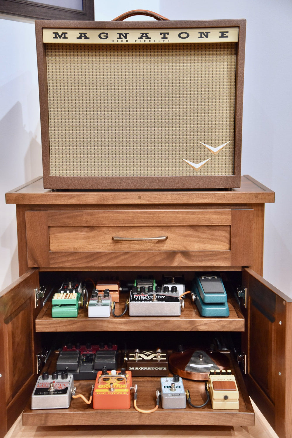Cherry Amp Stand with the amplifier on top and doors open showing effects pedals on the roll-out shelves