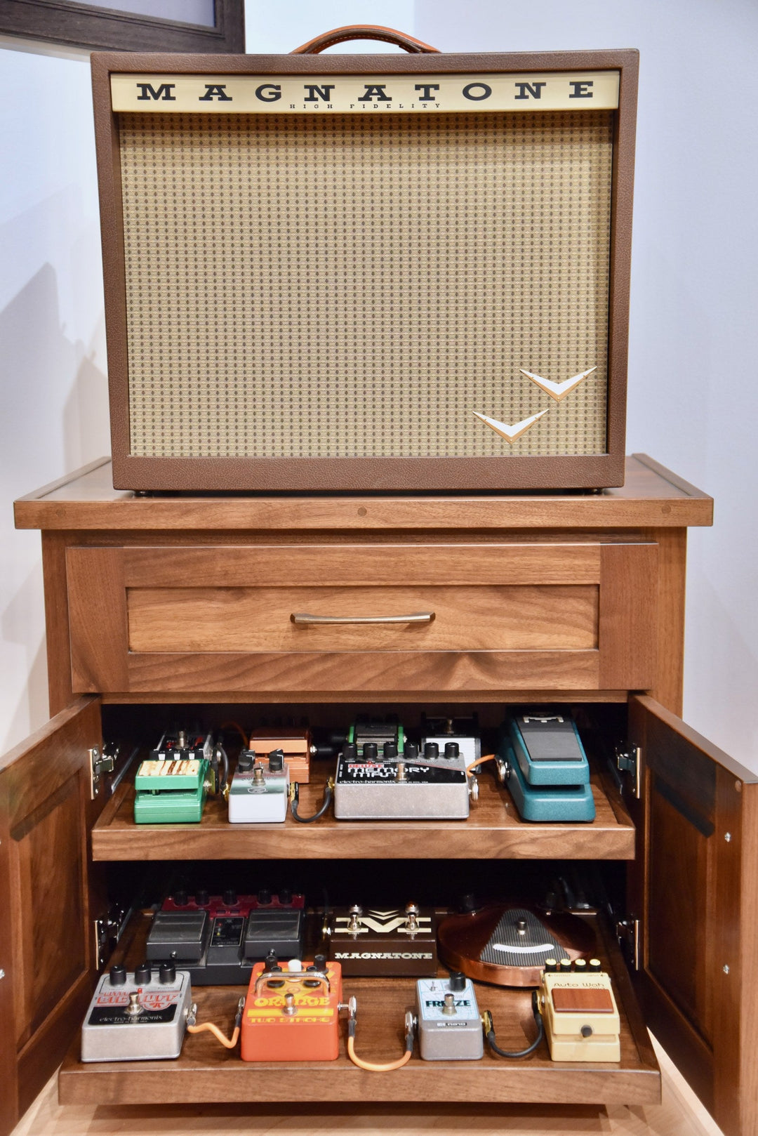 Cherry Amp Stand with the amplifier on top and doors open showing effects pedals on the roll-out shelves