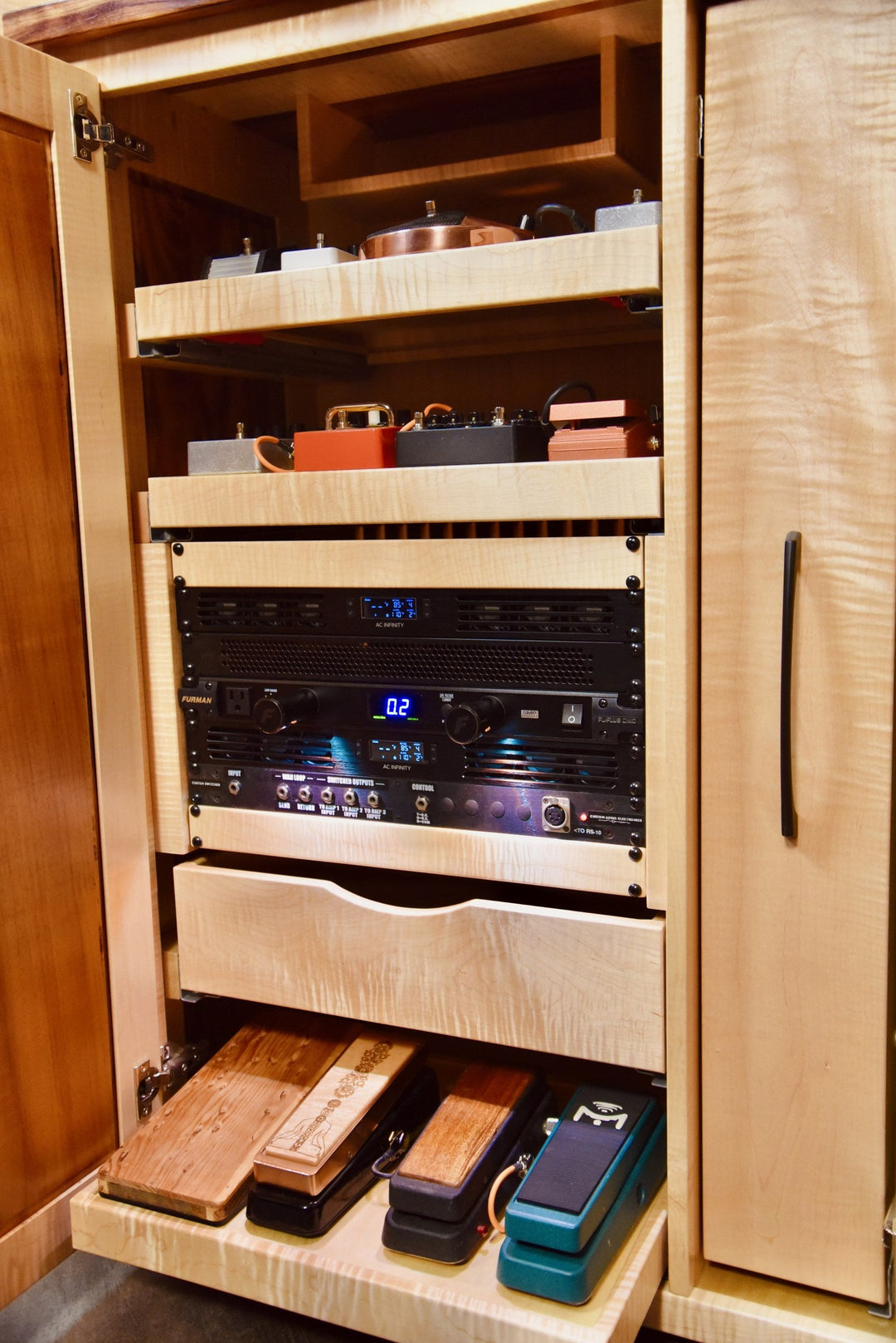 Effects Rack Cabinet open with pedals on the shelves and the rack unit lit