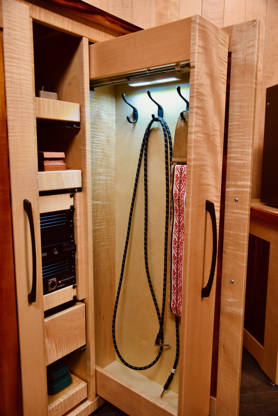Tall pull-out cubby with guitar straps and cables on integrated hooks
