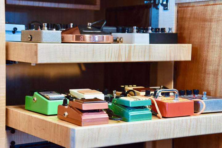 Pull-out pedal shelves loaded with effects pedals