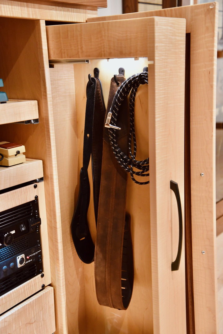 Guitar straps hanging in the Effects Rack Cabinet storage cubby