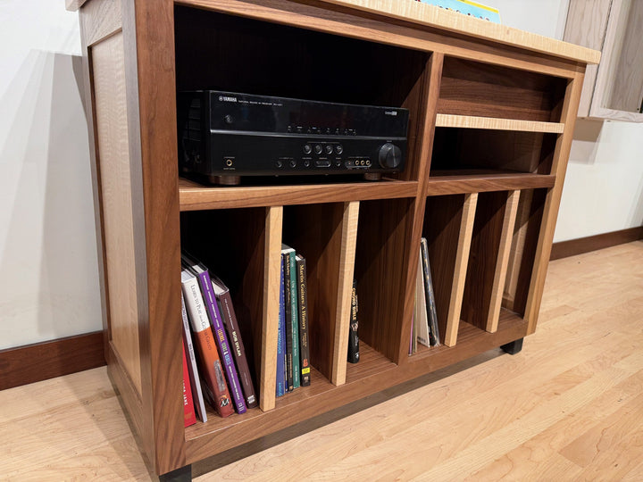 Three quarter view showing the figured maple frame against the walnut top