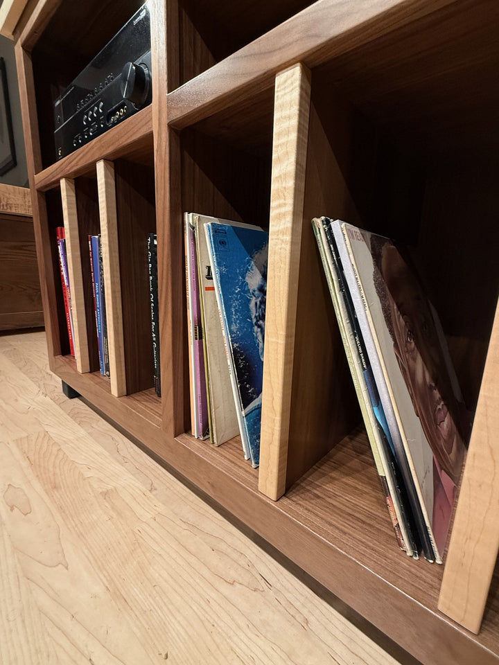 LPs filed upright between hardwood dividers in the lower bays