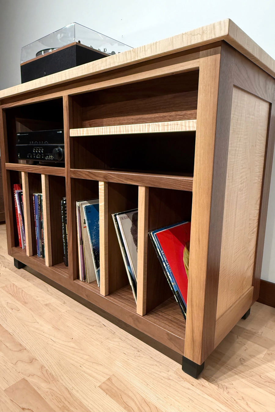 Record Console in flamed maple with walnut, records filed upright behind the dividers